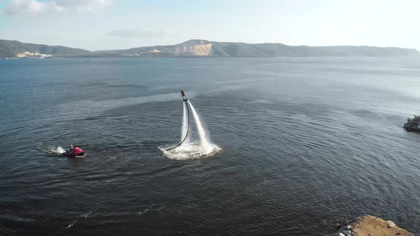 Flyboarding Training Near Sea Shore in Daytime, Man Is Riding and Watercraft Is Floating Near