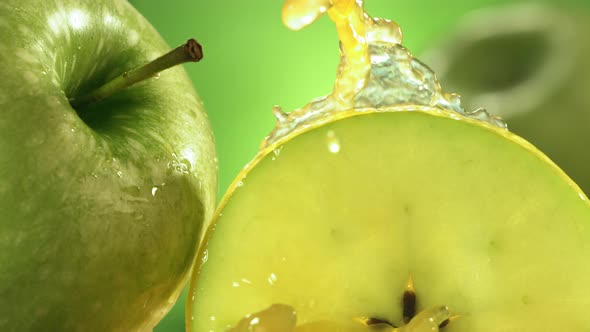 Slow Motion Shot of Green Apple Juice Splashing Through Apple Slices