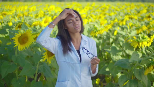 Tired Female Agronomist Standing in Cultivated Field