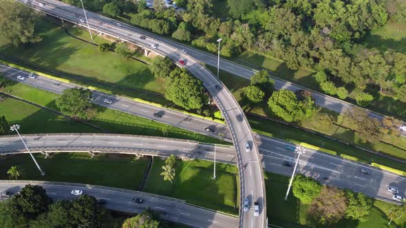 Aerial view car move at highway interchange with green surrounding