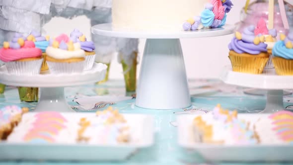 Unicorn cake with buttercream on the party table at little girl's birthday party.