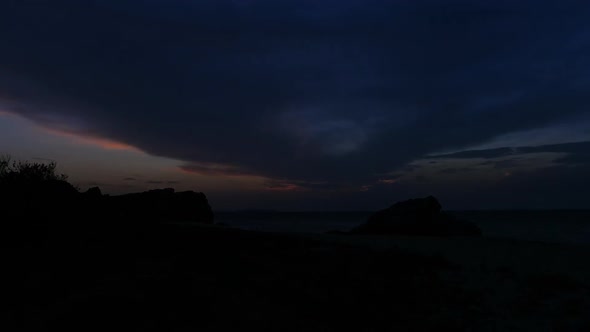 Sunset Between Rocks in the Sea Surface. Mountains Against the Sky with the Rising Sun.