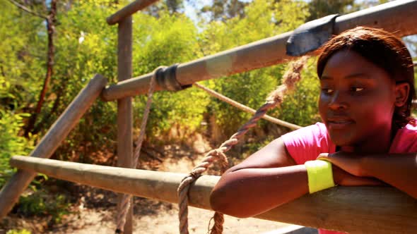 Tired woman relaxing on outdoor equipment during obstacle course