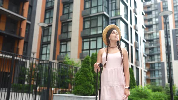 Young Woman Walks with a Suitcase on the Street