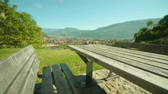 Table and Benches on Green Meadow with Rovereto View