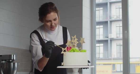 The Confectioner Decorates a Birthday Cake in the Confectionery Shop