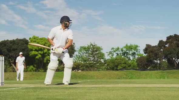 Side view of cricket player shooting in the ball