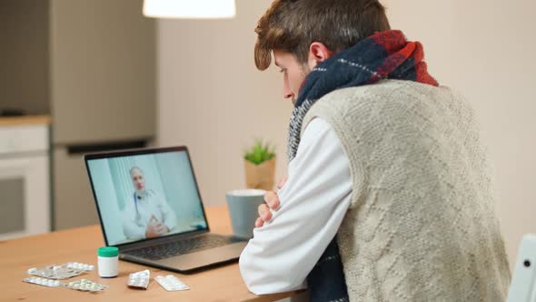 Man in Selfisolation Communicates with a Doctor By Video Call Using a Laptop a Patient Consults a