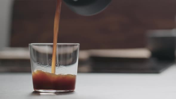 Slow Motion Pour Coffee in Tumbler Glass on Concrete Countertop with Copy Space