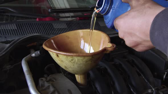 Pouring New Clean Synthetic Oil Into The Vehicle Engine