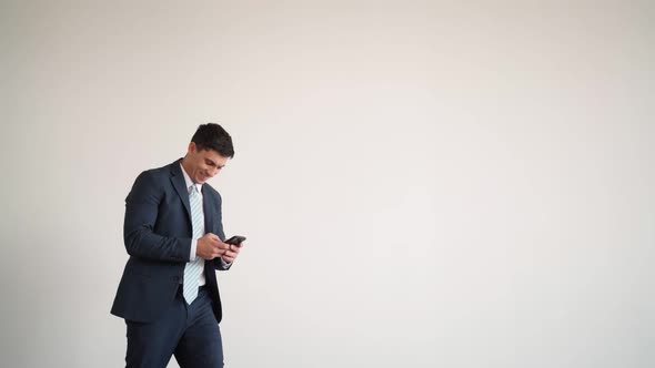 Businessman in Blue Jacket and Tie Texting on Phone Stumbles and Comically Falls