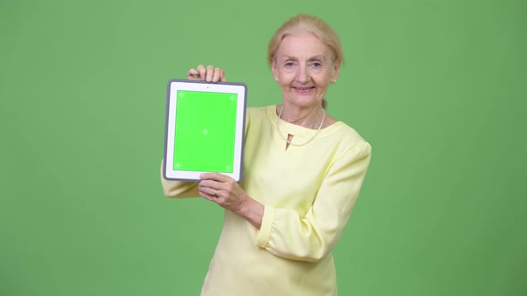 Beautiful Happy Senior Businesswoman Showing Digital Tablet