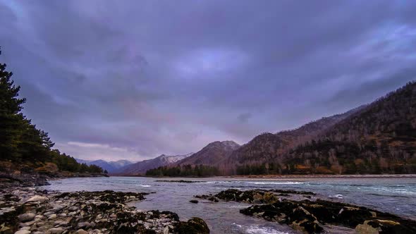 Time Lapse Shot of a River Near Mountain Forest. Huge Rocks and Fast Clouds Movenings.