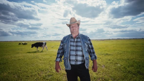 The rancher in a cowboy hat and denim. Portrait of a farmer