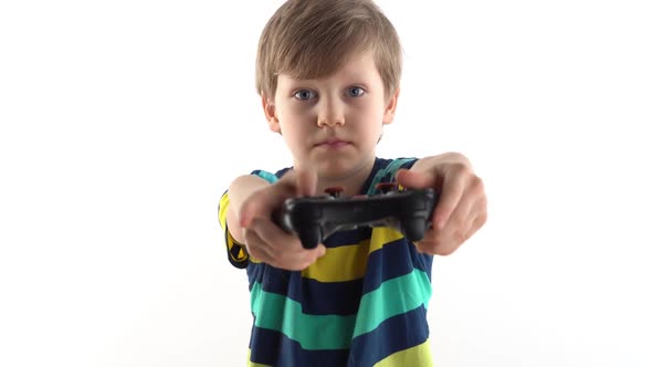 Little Boy in the Studio on a White Background Plays the Joystick in Video Games