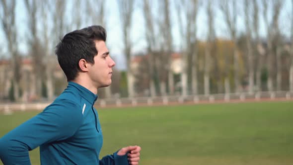 Fitness Young Man Running Outdoor at Sport Stadium. Male Runner Running Outside on Athletics Track. 