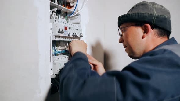 The Master Electrician Strips the Insulation From the Cable for Connection to the Circuit Breakers
