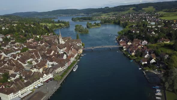 Aerial dolly in of Rhine river and bridge in Stein am Rhein picturesque town, green valley and hills