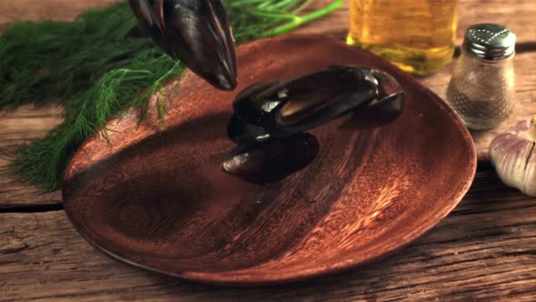 Super Slow Motion Boiled Mussels Fall Into a Wooden Plate