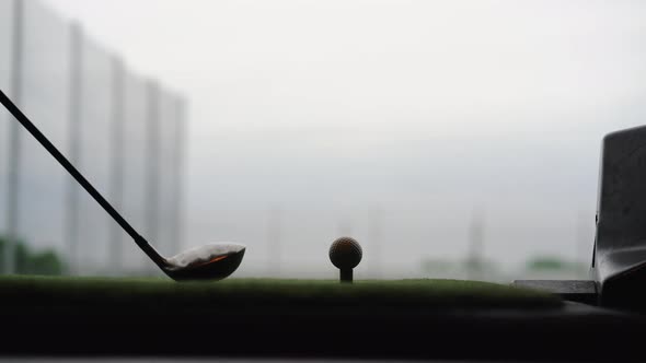 Close-up of Golf Ball on Tee with Golf Club Overlooking Driving Range at Topgolf