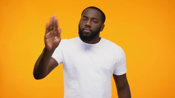 Young Black Guy Showing Stop Gesture With Palm, Isolated on Yellow Background