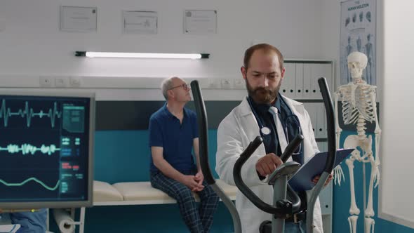 Portrait of Physician Using Stationary Bicycle to Help Patients