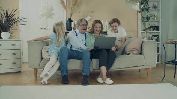 Happy Kids and Their Grandparents Are Using a Laptop