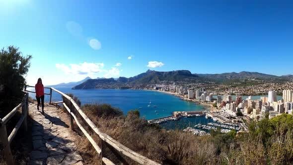 Tourists visit Calpe watches coast from path above the city in the penon the ifach.