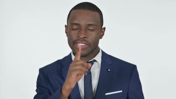 Finger on Lips By Angry African Businessman White Background