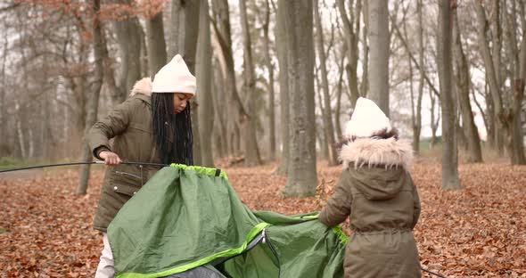 Black Race Sisters Putting a Tent in a Forest