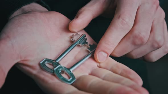 Hand Holding Home Keys and Showing It to the Camera Closeup