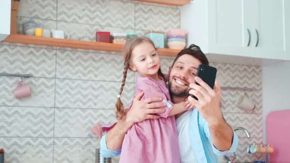 Smiling father and daughter taking selfie on smartphone. Dad and daughter spending time together