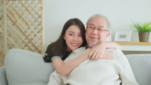 Portrait of Asian beautiful daughter hugging and sit with older father.