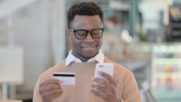 Creative African Man with Successful Online Shopping on Smartphone