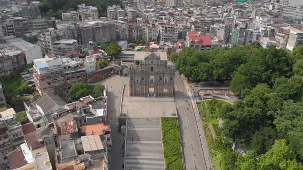 Reversing tilt reveal aerial view of Ruins of Saint Paul's, Macau and surrounding area