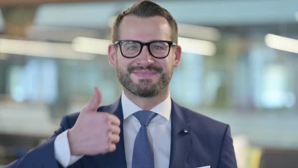 Portrait of Middle Aged Businessman Showing Thumbs Up Sign