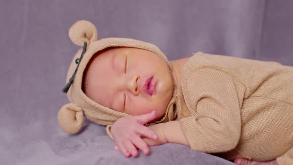 happy newborn baby weaing cute Mouse costume lying sleeps on a grey blanket comfortable