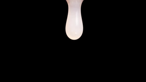 White Drop of Viscous Liquid Isolated on Black Background. Shampoo or Cosmetic Products Concept