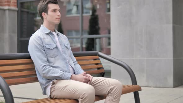 Serious Casual Young Man Sitting Outdoor