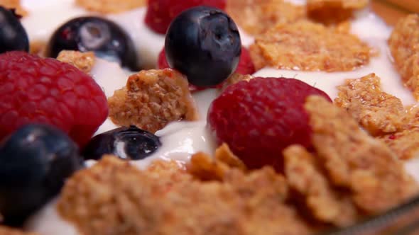 Raspberries and Blueberries Fall on Cereal Yogurt