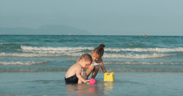 Happy and Carefree Children Playing By the Sea with Sand . Children Playing, Brother and Sister Play