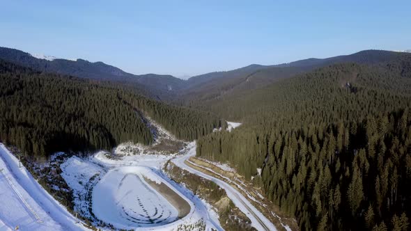Aerial view of the ski resort with snowy mountain slopes and winter trees. Stock footage. alt