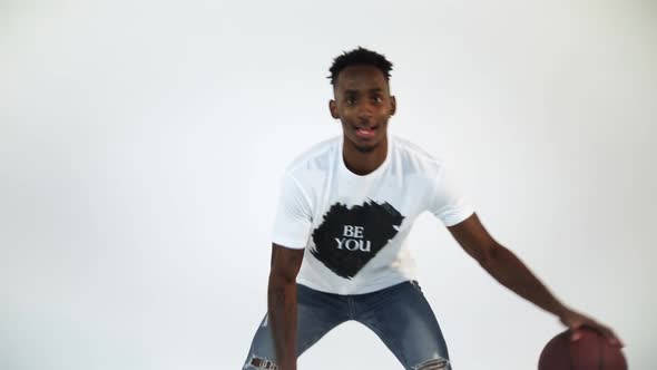 Slow Motion shot of an African American dribbling a basketball. Shot in a studio with a white backgr