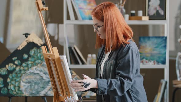 Side View Art Worker Redhaired Busy Woman in Glasses Talented Artist Girl Student of Painting Class