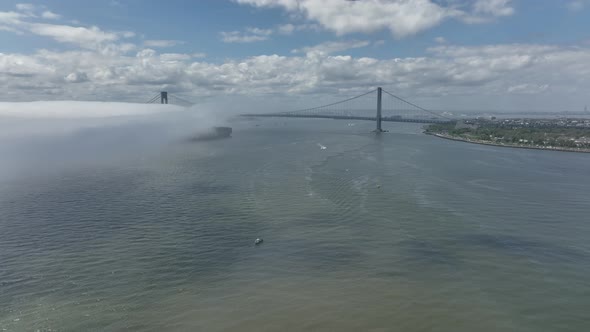 An aerial view of Gravesend Bay in Brooklyn, NY on a cloudy day. There is a low dense fog over the w