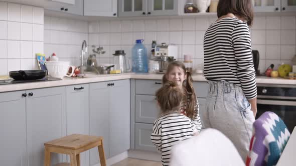 Funny Young and Cheerful Mother is Playing with Daughters