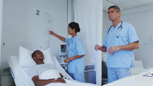 Front view of Caucasian male doctor using invisible screen in ward at hospital