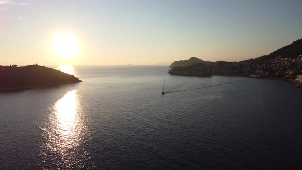 Aerial shot at sunset of the Adriatic Sea and Dubrovnik coast with a boat