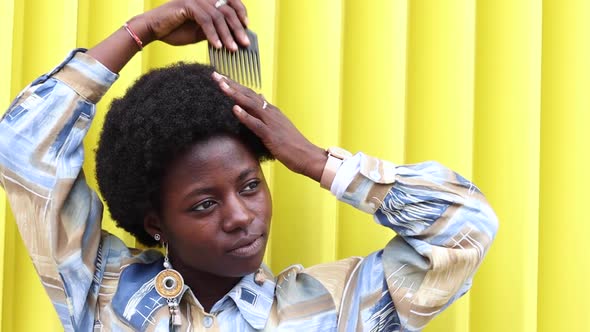 Stylish black woman brushing hair