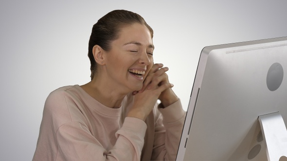 Woman Watching Videos on Computer and Laughing on Gradient